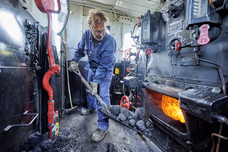 Heizer einer Dampflok bei der Arbeit