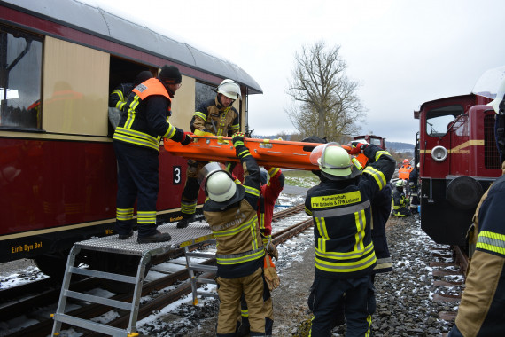 Feuerwehrleute bei Evakuierungsaktion aus einem Bahnwaggon