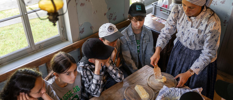Museumsführerin streicht Butter auf ein Brett