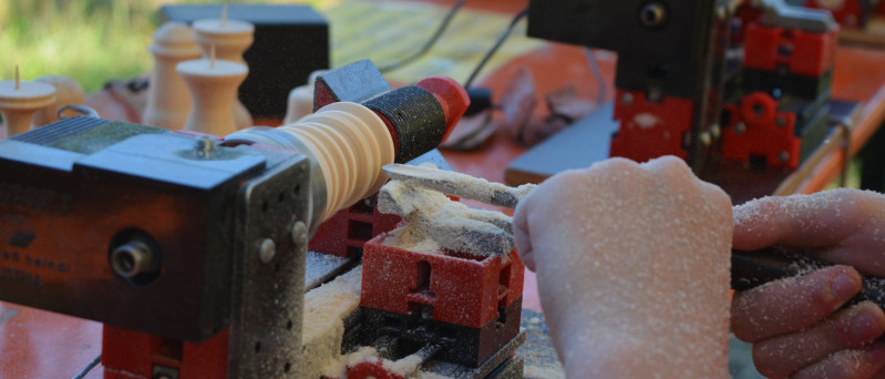 Hände arbeiten an der Drechselnmaschine