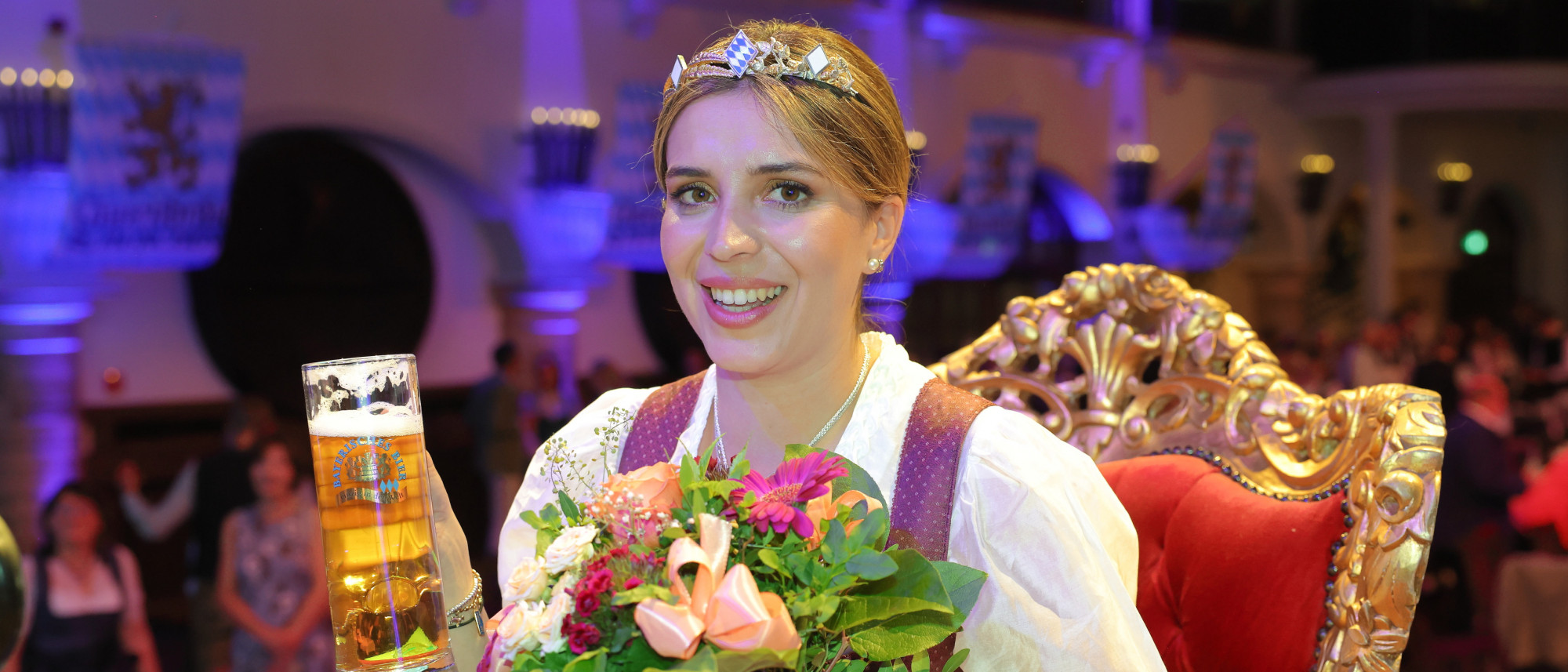 Bayerische Bierkönigin mit Blumen und Bierglas in der Hand