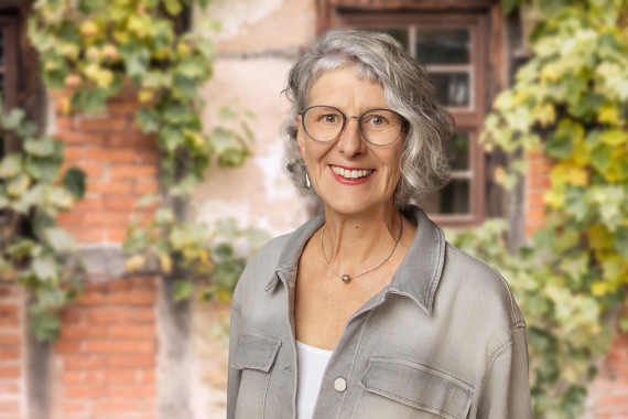 Monika Trost, Museumsverwaltung, vor begr&uuml;nter Hausfassade