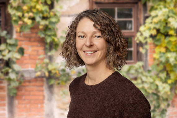 Linda Wolters, stellvertretende Museumsleiterin vor begr&uuml;nter Hausfassade