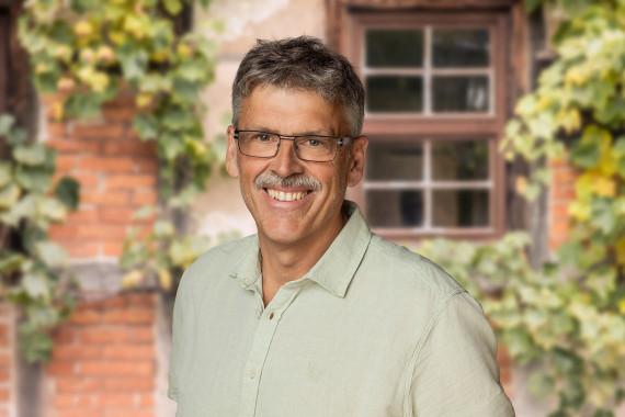 Michael Herbert, technischer Leiter, vor begr&uuml;nter Hausfassade