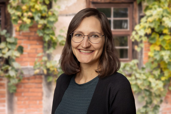 Patricia Linsenmeier, Mitarbeiterin Presse-, &Ouml;ffentlichkeitsarbeit und Marketing vor begr&uuml;nter Hausfassade