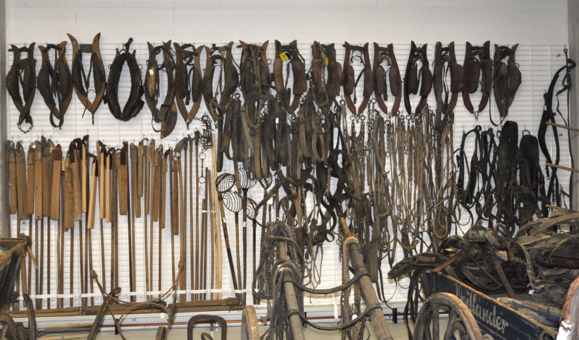 Objekte h&auml;ngen aufgereiht an einer Wand de Museumsdepot