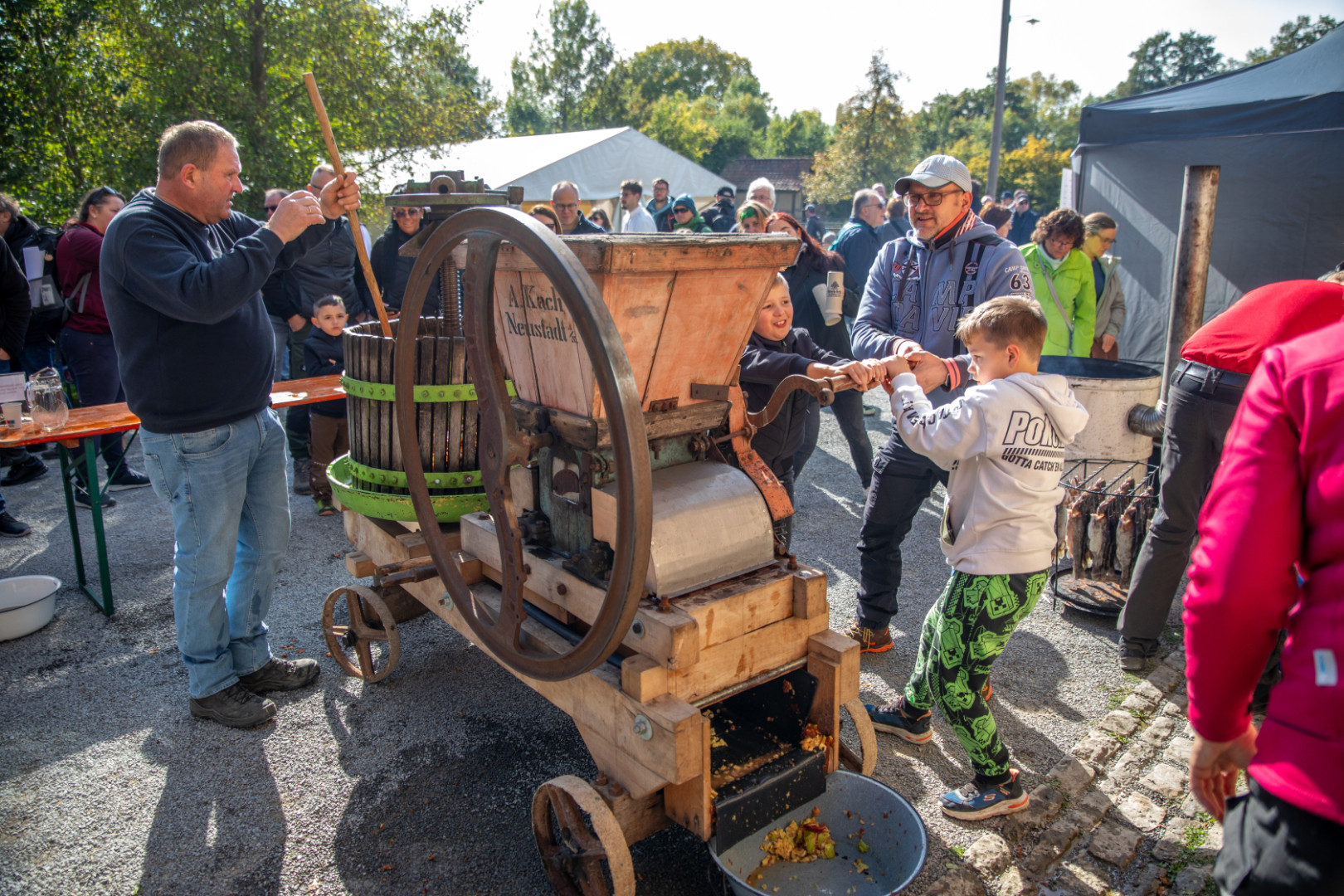 Mehrere Menschen bedienen eine Apfelsaftpresse