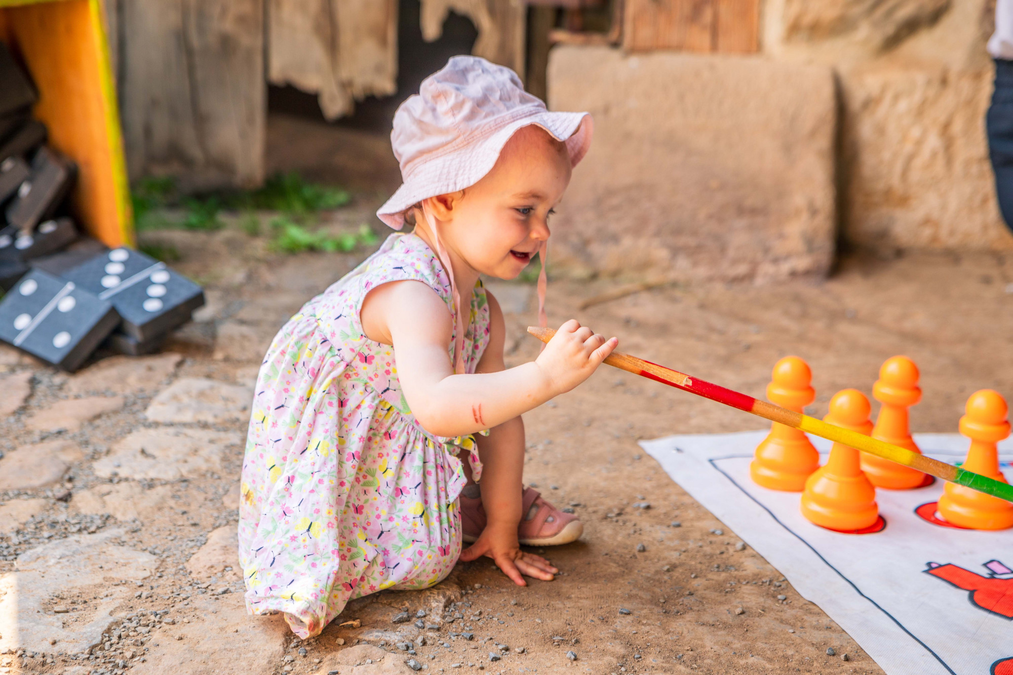 Kleines M&auml;dchen erkundet einen XXL-Mikado Stab