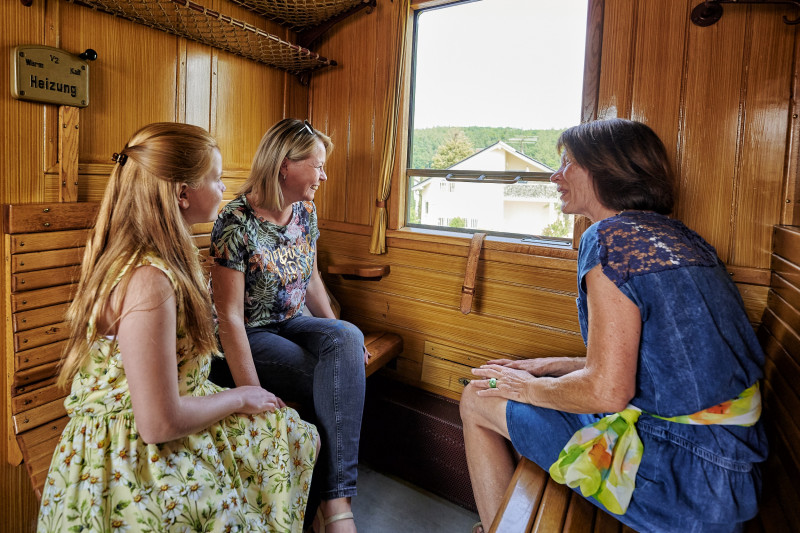 Zwei Frauen und ein M&auml;dchen in historischem Eisenbahn-Waggon